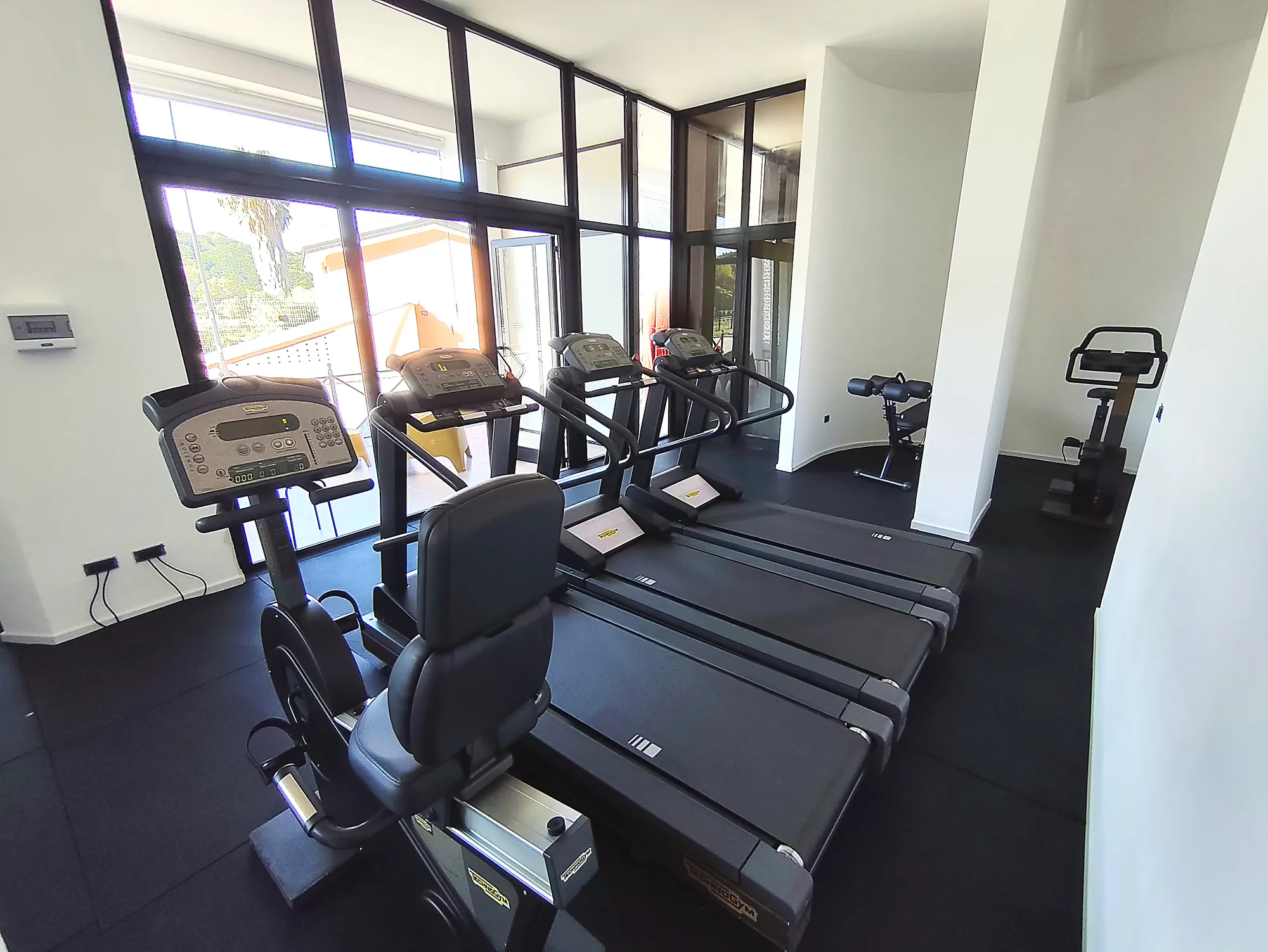 Area cardio con tapis roulant vicino alle finestre